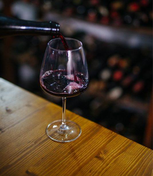 Vino rosso versato nel calice sul bancone